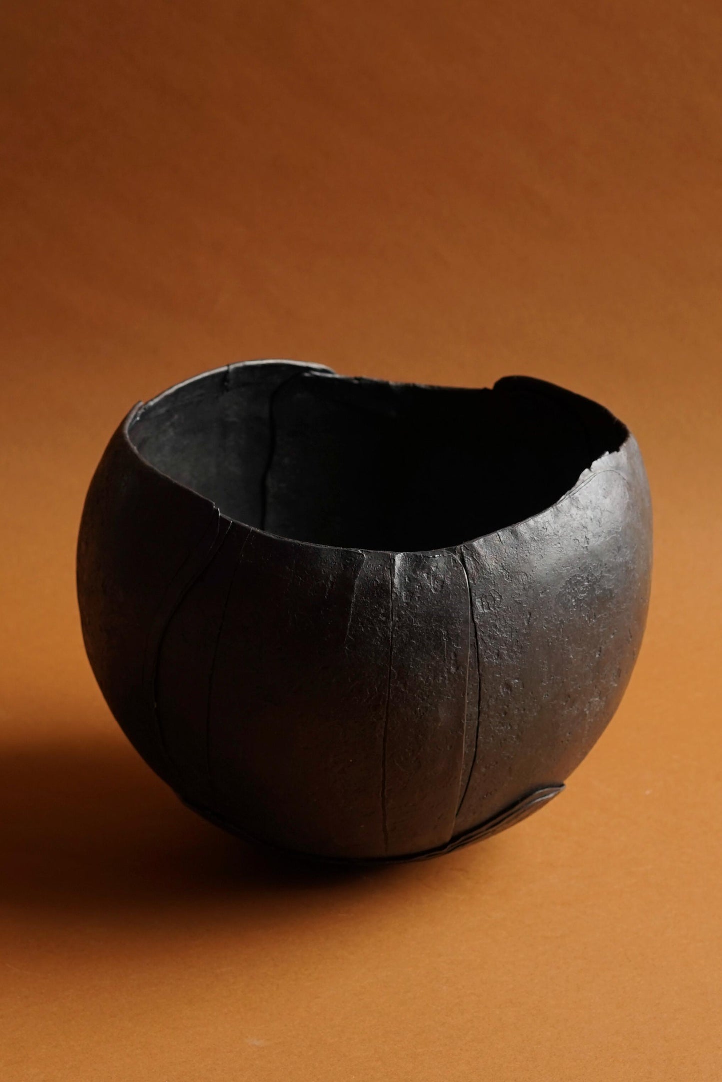 ALT= The Gun Metal piece from Daniel Freyne's Armoured Vessel series. Sat on brown paper in the studio at Bard Scotland.