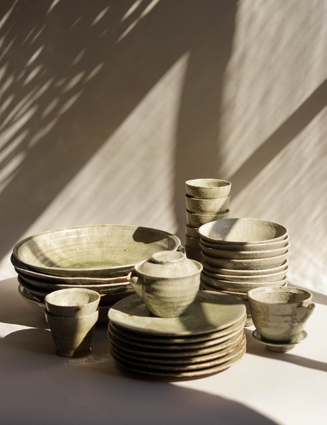 ALT=Full range of ceramic crockery by Ingot Objects including the ash glazed gaiwan ash front and centre.
