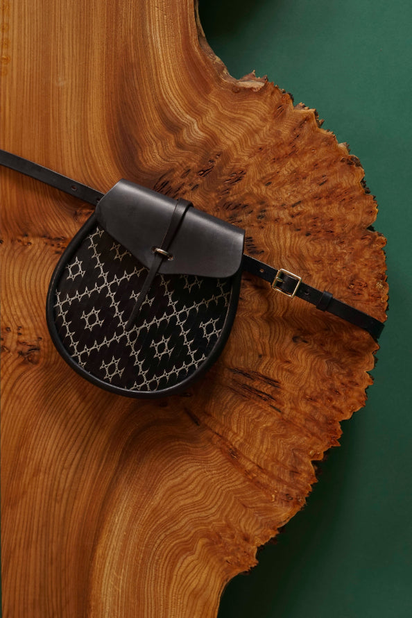 ALT=Navy sporran bag by Iseabal Hendry with white lace work panel, crafted by McRostie into the bag you see.