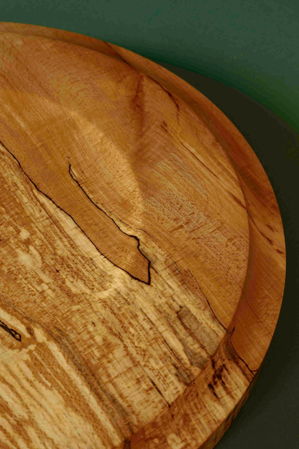 ALT=The underneath of the Spalted Beech serving platter. A gently gentle concave void and small foot.
