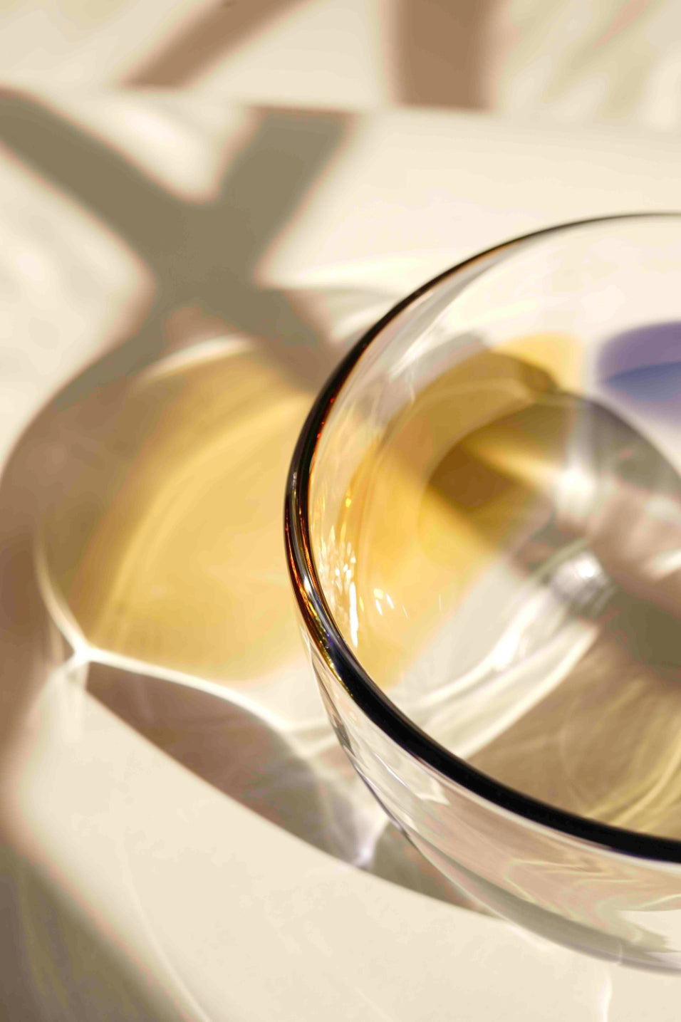 ALT=One side of the violet, lichen and amber petal bowl is in shot of the camera. The amorphous bowl edge is strikingly thick and layers of colour and light can be seen reflected from it.