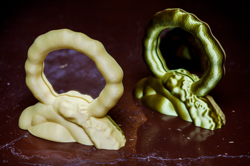 ALT=Moon mirror by Wobbly Digital Studio. 3D printed works made in Glasgow. Soft yellow on one side, and a satin finish gold on the reverse. Both finishes shown in this image.