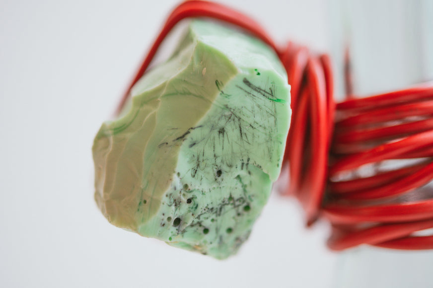 Photograph by Jaro Mikos ALT=Close up shot of Piece 3 from Juli Bolaños-Durman's Powerful Ordinary Bonds series. Red coated wires hold together found glass forms.