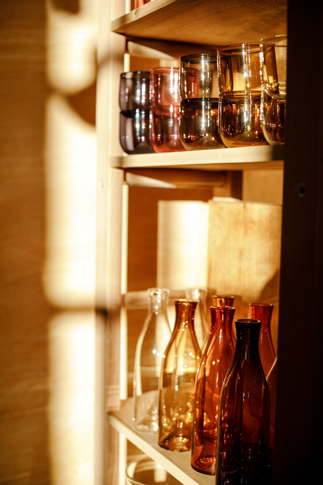 ALT=The shelves at Bard Scotland. Lindean Mill carafes and cups dazzle in the morning sun.