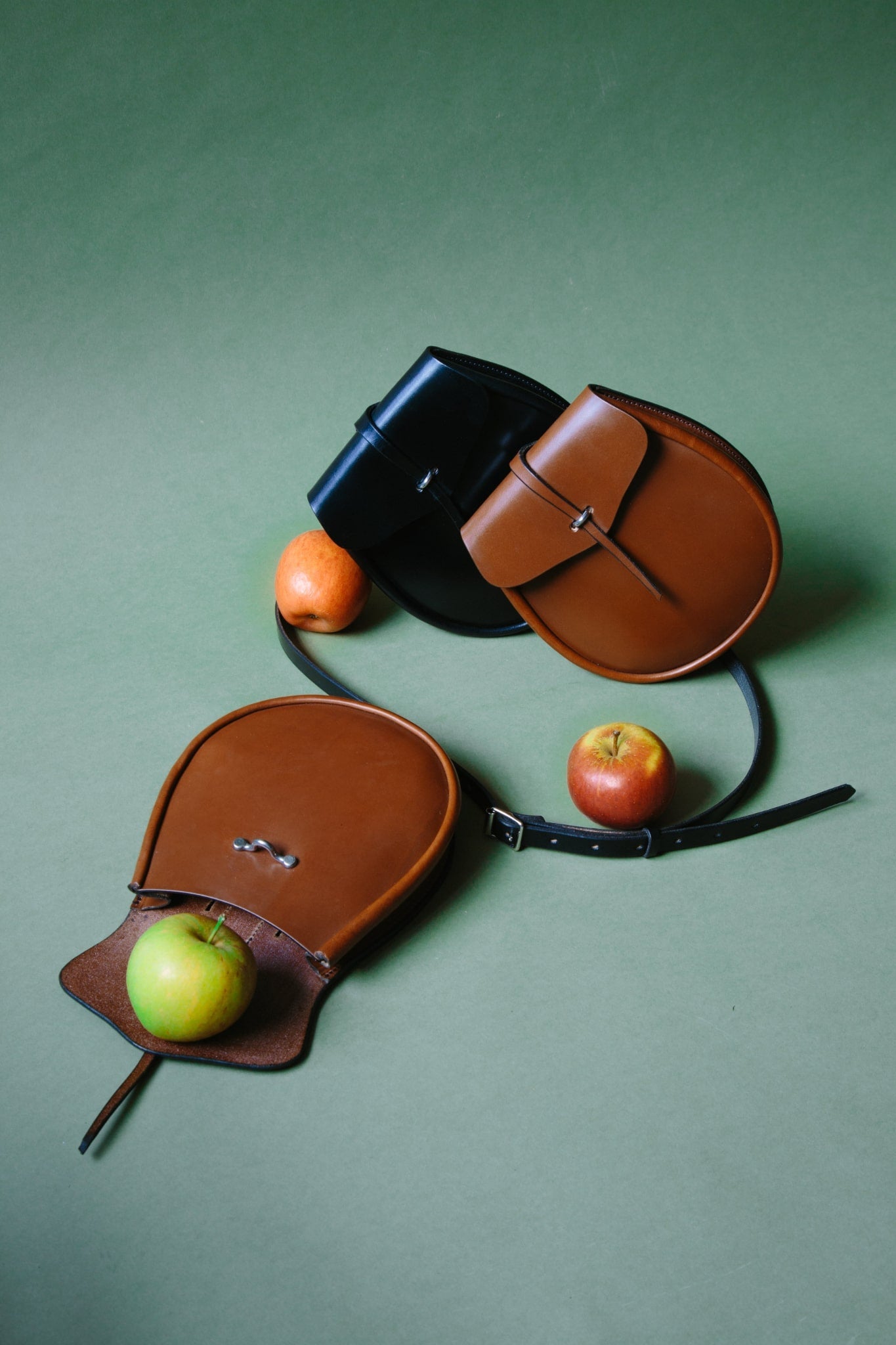 ALT=A group of three leather sporrans, one opened with an apple falling out.