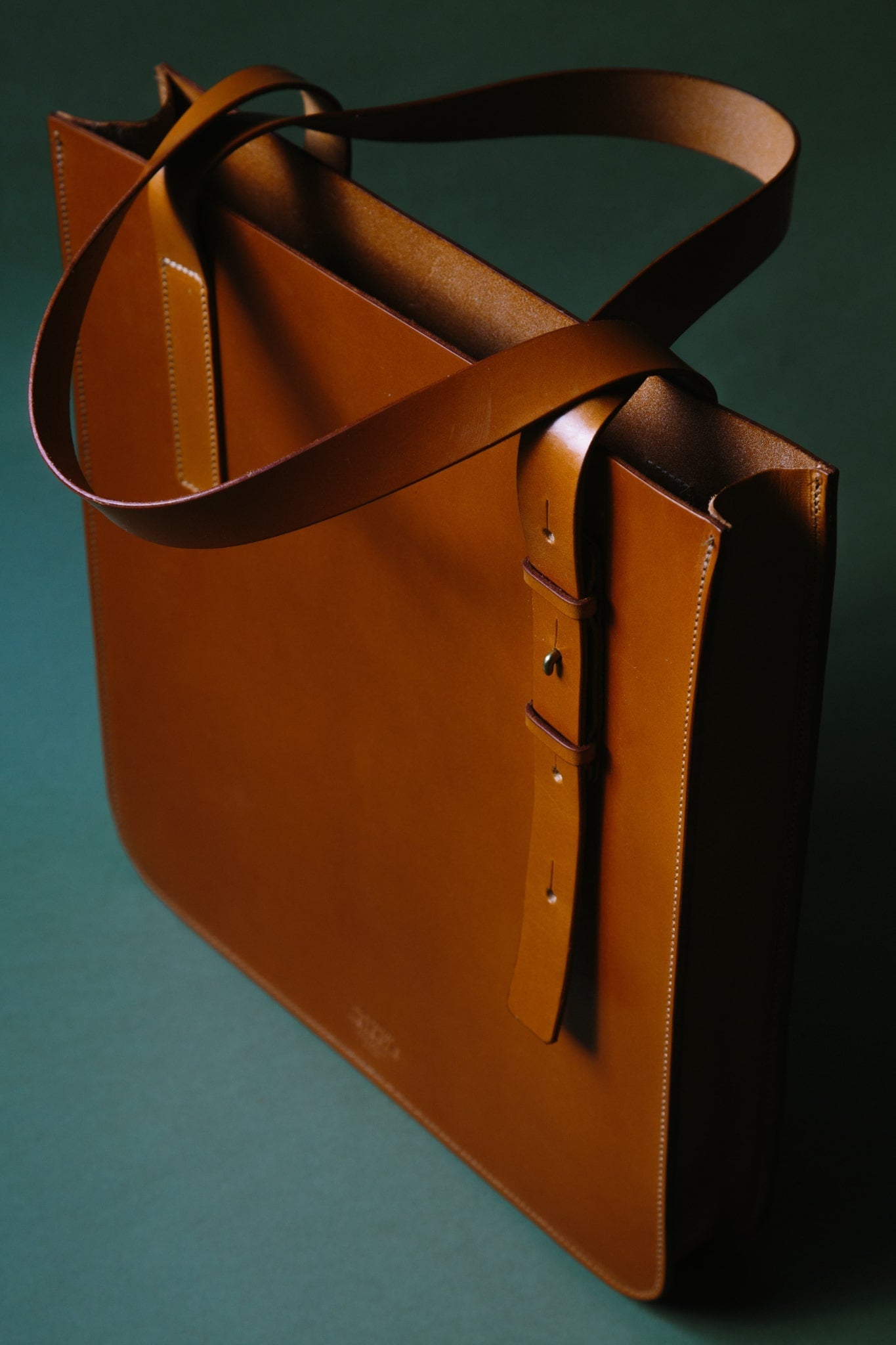 ALT=A third angle of the leather Lismore tote bag where the length of the handle can be seen and the inside of the unlined bag.