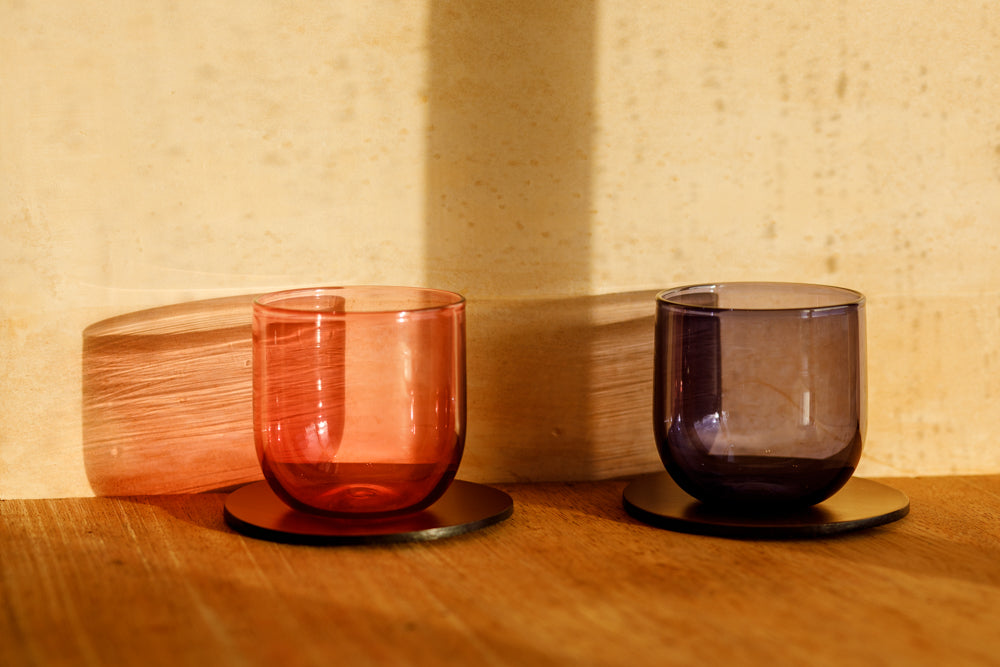 ALT=Shot at Bard, two Lindean Mill handblown glass cups, rested on bridle leather coasters from McRostie Leather.