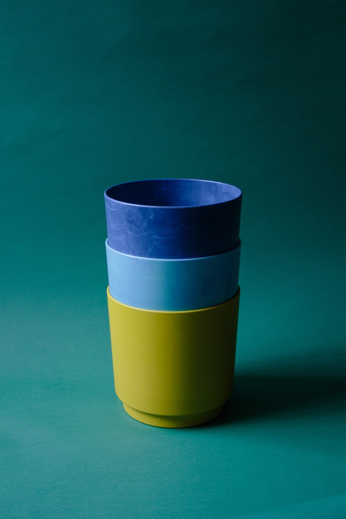 ALT=A stack of three recycled plastic plant pots in yellow, blue and navy.
