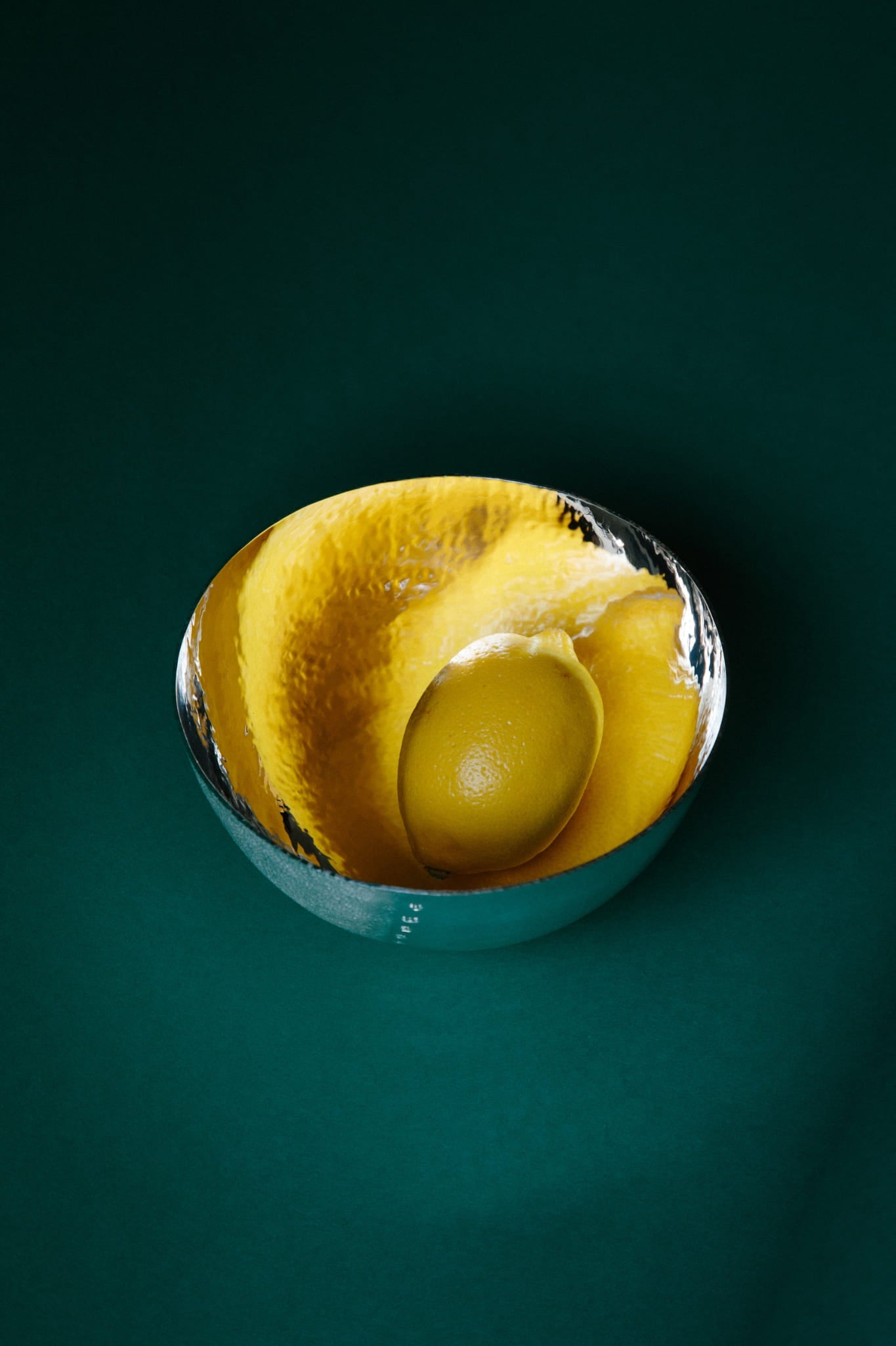 ALT=A bright dimpled lemon demonstrates the reflective inner surface of a sterling silver bowl.