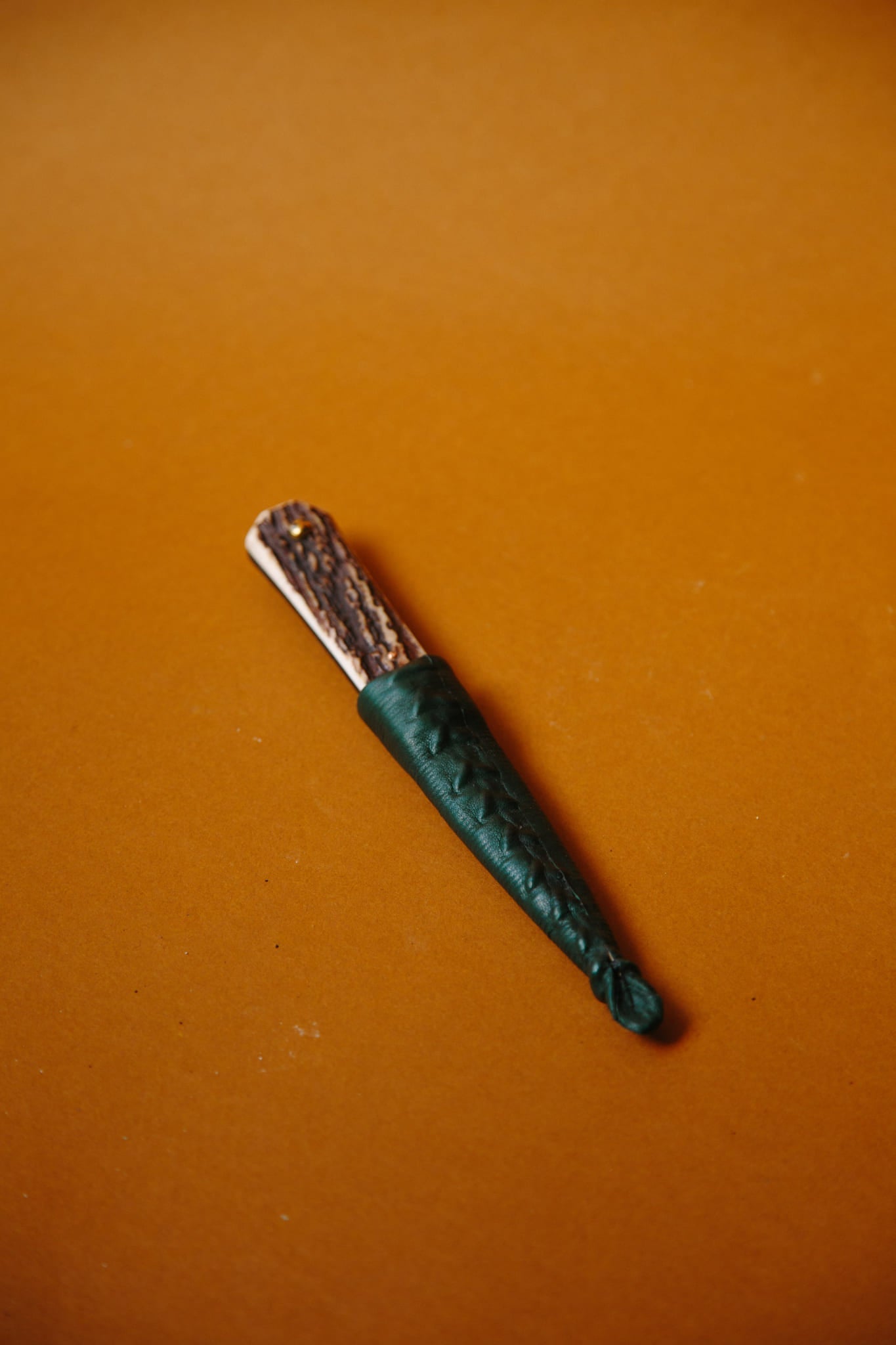 ALT=An Antler Sgian Dubh knife with its handcrafted leather sheath.