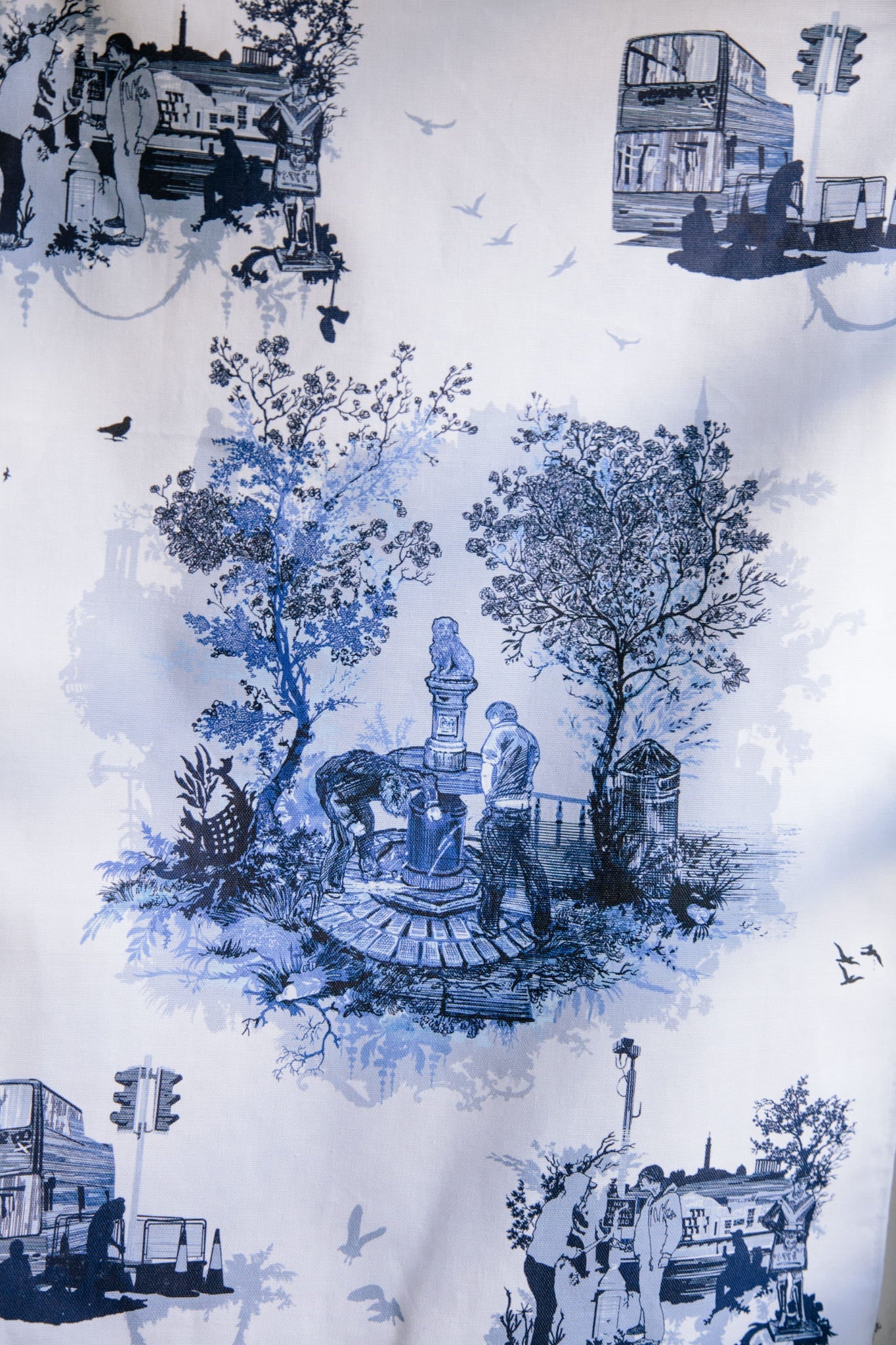 ALT=The tea towel design in blue. Showing the endless tram roadworks, shady goings on in the shadow of Carlton Hill and a couple of miscreants relieving themselves on Greyfriars Bobby. The grit and the glamour of Edinburgh life.