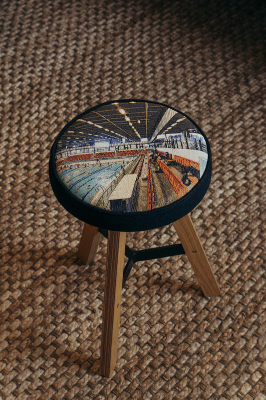 ALT= Photo of the Embroidered Commonwealth Stool by Laura Lees. Depicting Edinburgh's Royal Commonwealth Pool by RMJM.