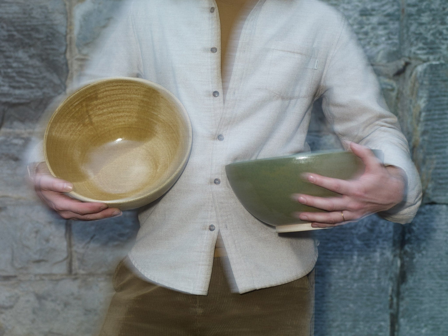 ALT=James holding two Claire Henry bowls in ochre and green