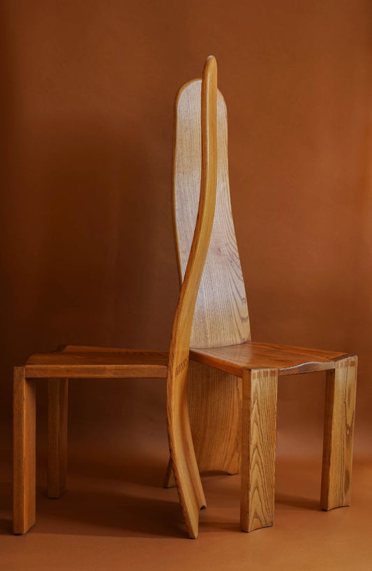 ALT=Elm high-backed chairs with carved seats and curved, laminated backs that stretch to the ground.
