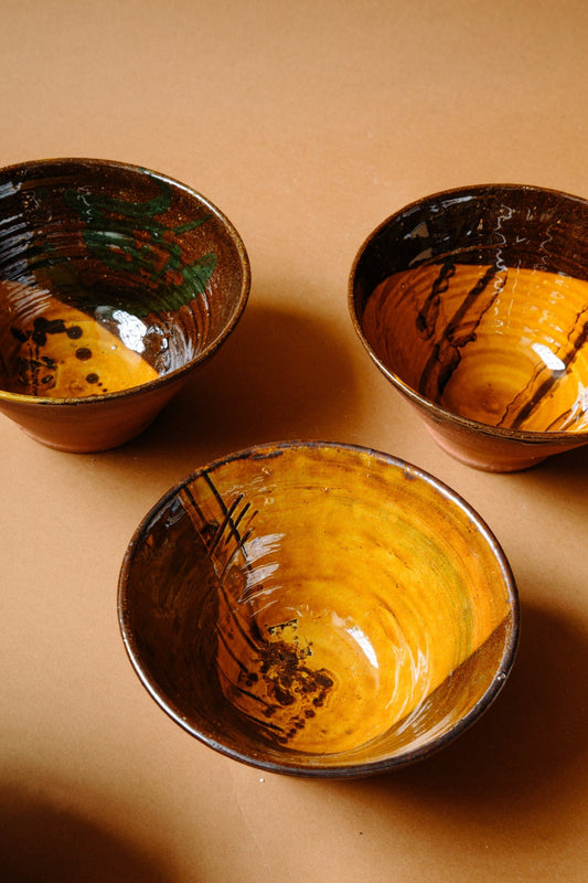 ALT=Mainly caramel and brown in colour, but each has expressive painterly marks and scratches. Three unique terracotta bowls.  