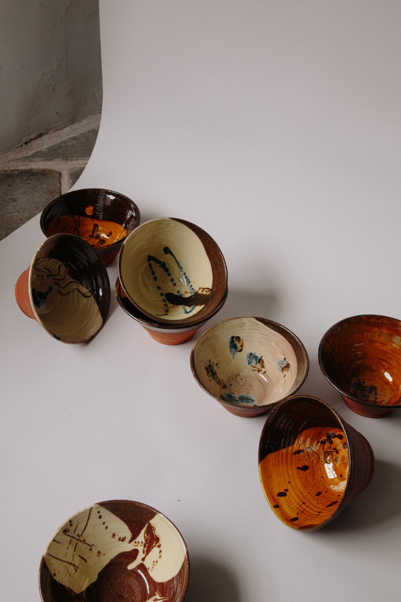 ALT=Eight ceramic bowls in shades of caramel, white and brown. The glazes have been applied in a painterly manner and give each a totally unique appearance. No two are the same.