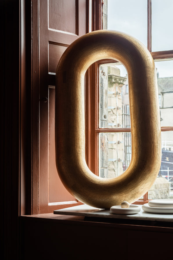 ALT=Large golden ceramic loop by James Rigler. A sculptural piece, pictured here in the window of Bard. A Leith based shop and gallery celebrating Scottish craft.
